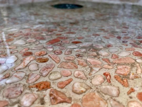 A close-up of the shower base lined with textures pebbles to give a spa-like elegance.