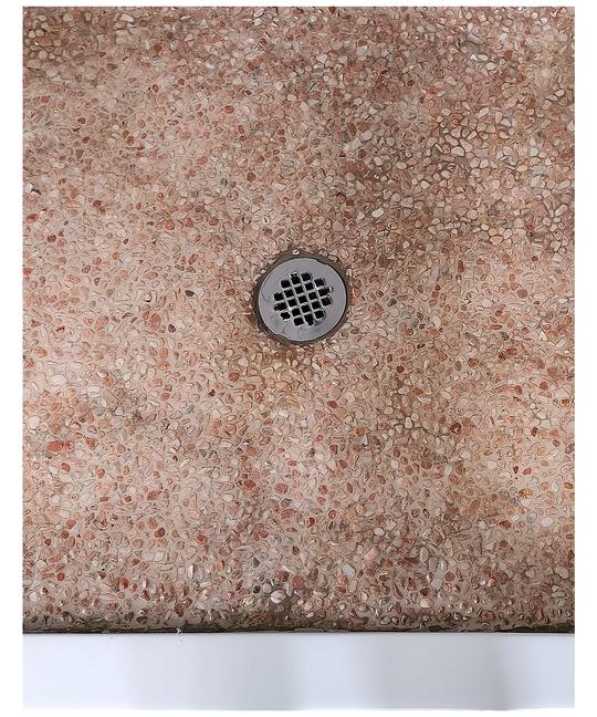 A shower base flooring with epoxy covered neutral colored pebbles.